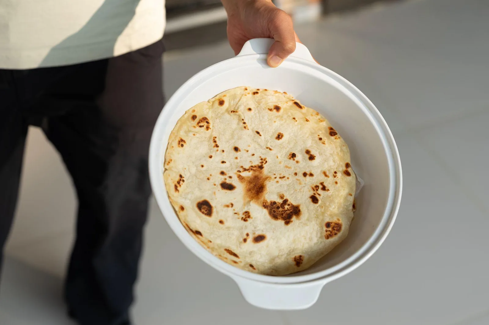 A plate of fresh paratha being carried to the table