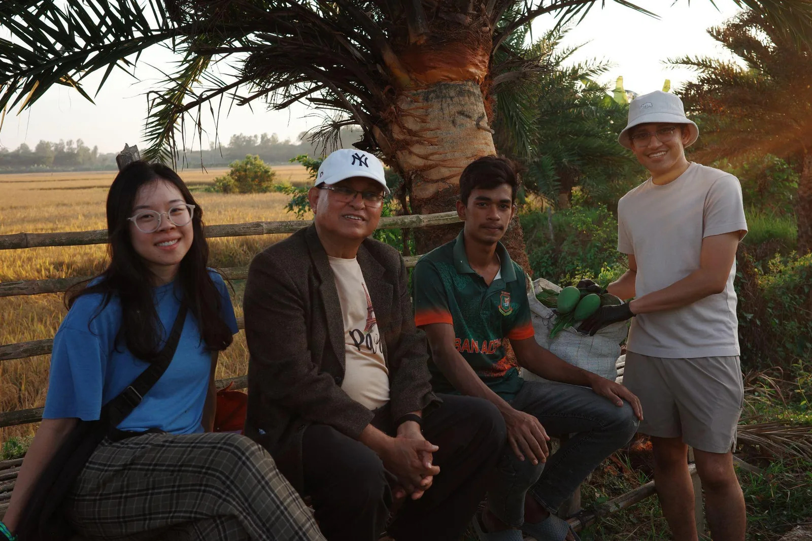 A group sitting together at the edge of a golden rice field