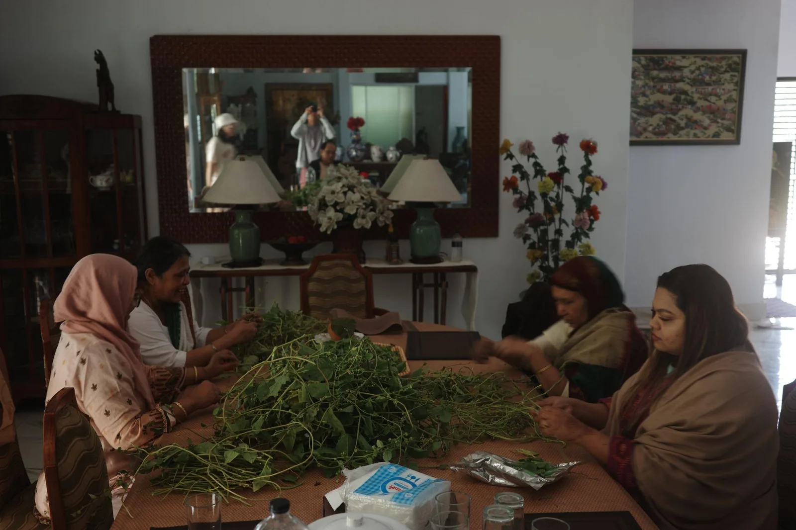 Women sorting and preparing greens together at a table
