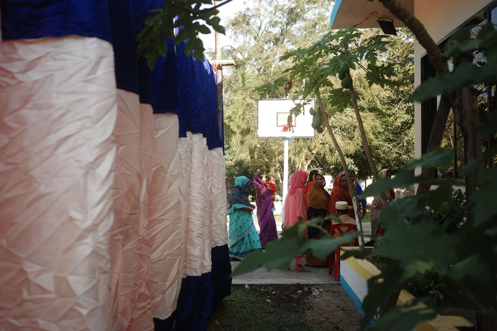 Draped fabric and gathered guests at a village party
